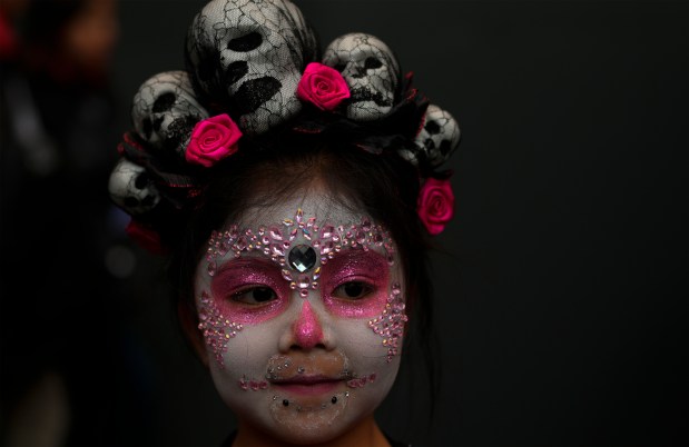 A girl with her face painted as a "Catrina" collects candy during a Day of the Dead celebration in La Paz, Bolivia, Tuesday, Oct. 31, 2023. (AP Photo/Juan Karita)
