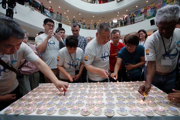 Family members and relatives of passengers on board of the missing Malaysia Airlines Flight 370 light candles during the tenth annual remembrance event at a shopping mall, in Subang Jaya, on the outskirts of Kuala Lumpur, Malaysia, Sunday, March 3, 2024. Ten years ago, a Malaysia Airlines Flight 370, had disappeared March 8, 2014 while en route from Kuala Lumpur to Beijing with over 200 people on board. (AP Photo/FL Wong)