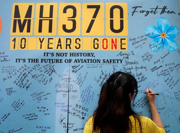 A woman writes well messages on the message board during the tenth annual remembrance event at a shopping mall, in Subang Jaya, on the outskirts of Kuala Lumpur, Malaysia, Sunday, March 3, 2024. Ten years ago, a Malaysia Airlines Flight 370, had disappeared March 8, 2014 while en route from Kuala Lumpur to Beijing with over 200 people on board. (AP Photo/FL Wong)