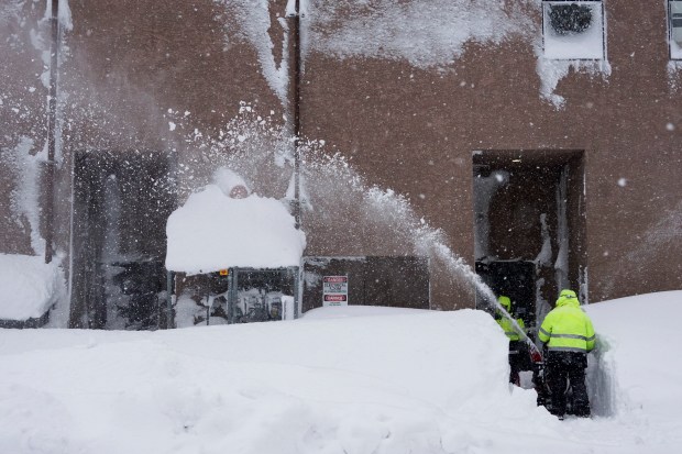 Snow is cleared from the entrance to a business during a storm, Sunday, March 3, 2024, in Truckee, Calif. (AP Photo/Brooke Hess-Homeier)