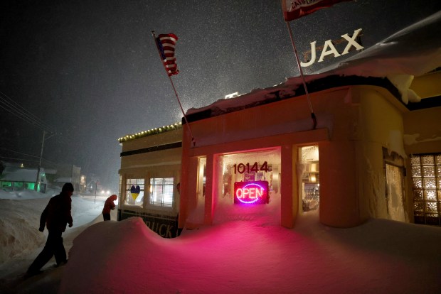 Patrons enter Jax At The Tracks diner past snow drifts in downtown Truckee, Calif., Sunday, March 3, 2024. (Jane Tyska/Bay Area News Group via AP)