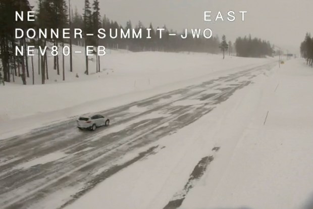 In this image from a Caltrans remote traffic camera, a car travels along Interstate 80 near Donner Summit, Calif., Monday, March 4, 2024. A powerful blizzard that closed highways and ski resorts had moved through the Sierra Nevada by early Monday. A long stretch of Interstate 80 from west of Lake Tahoe over Donner Summit to the Nevada state line finally reopened to all but big rigs. (Caltrans via AP)