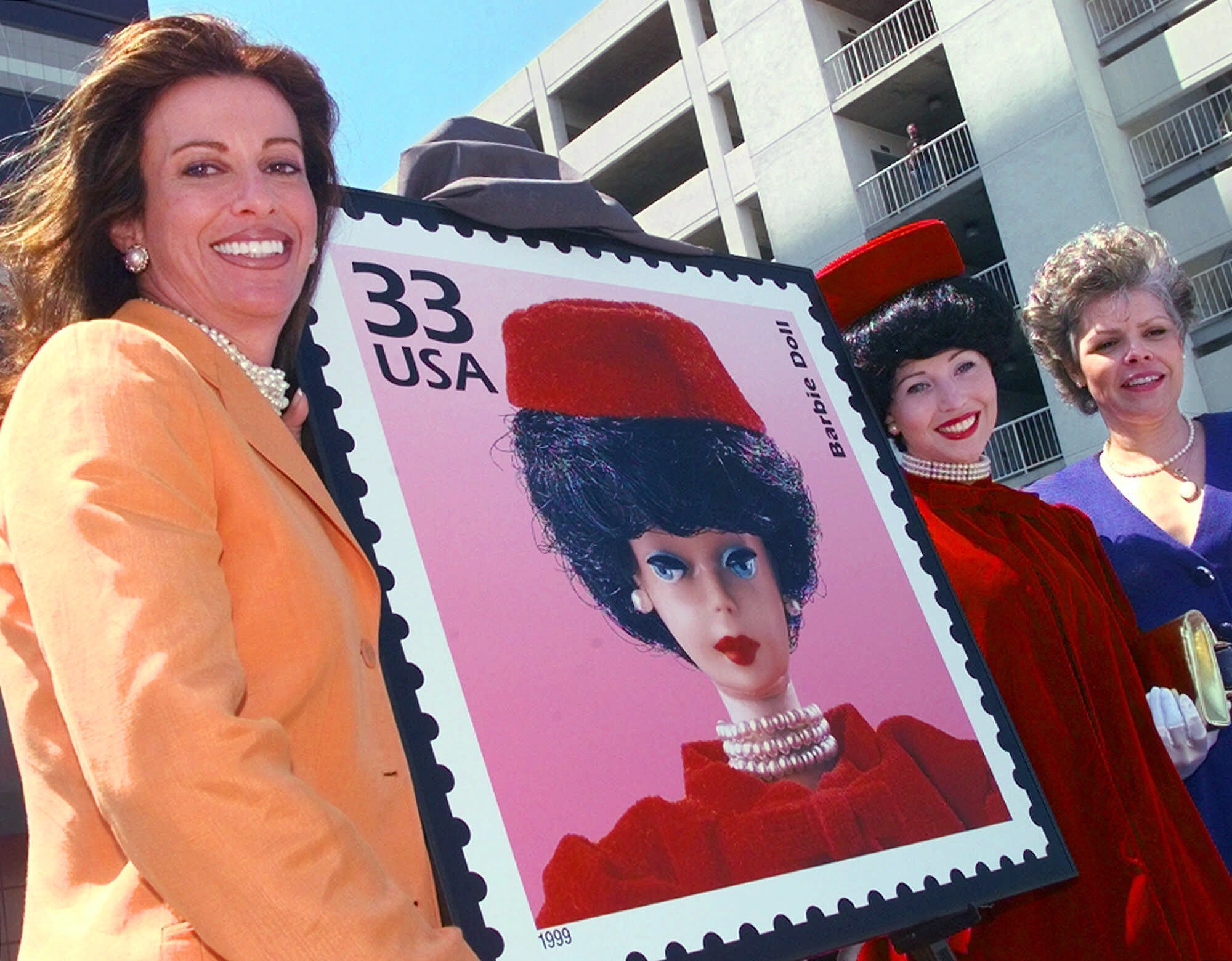 Jill Barad, left, chief executive officer of Mattel, Inc., poses with U.S. Postal Service consumer advocate Francia Smith, right, and actress Millicent Roberts as 