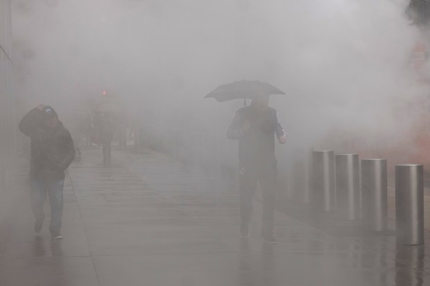 People walk through the rain and steam in midtown Manhattan on March 05, 2024 in New York City. (Photo by Spencer Platt/Getty Images)