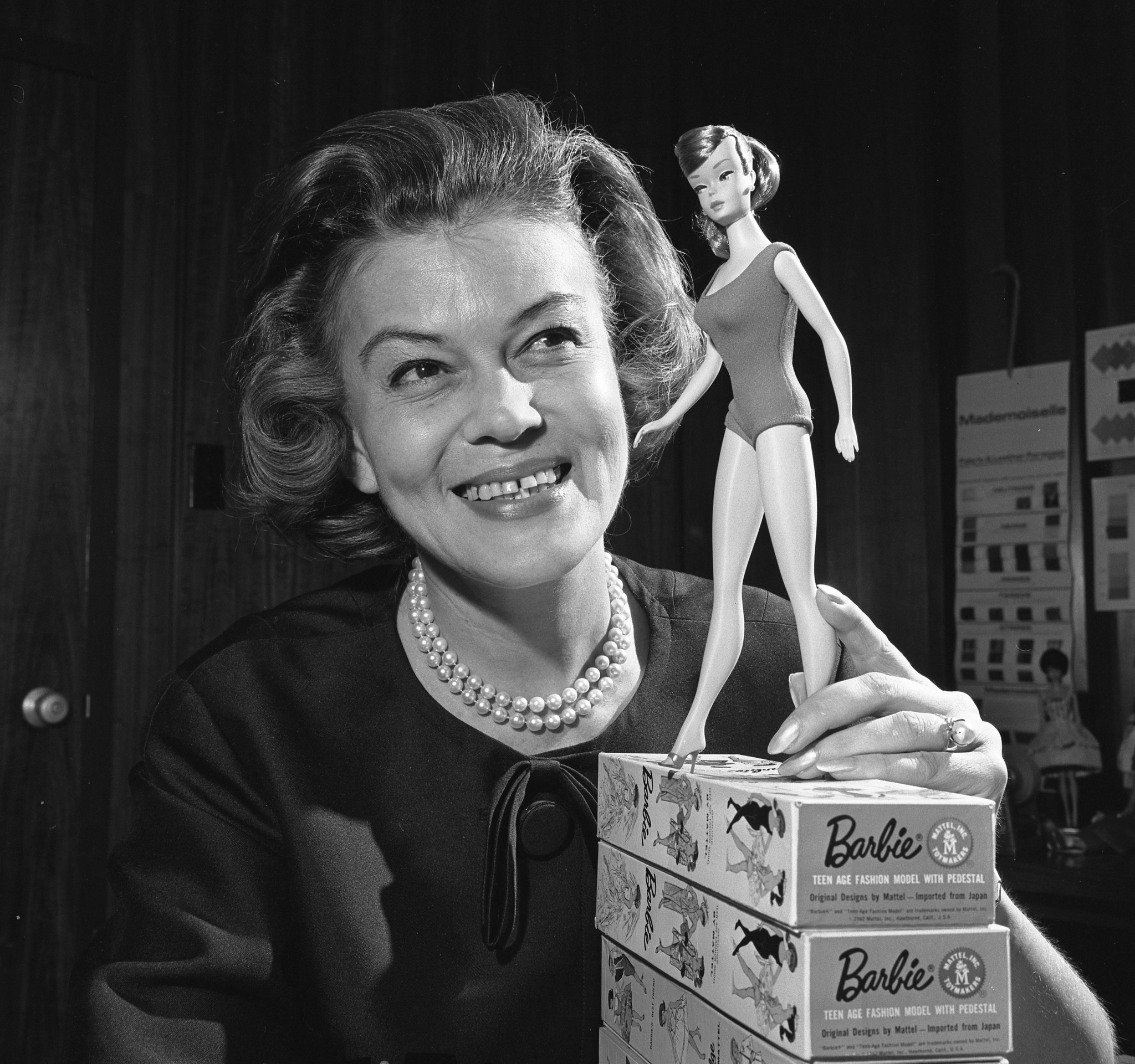 Charlotte Johnson, director of fashion for the highly successful Barbie doll, who is photographed here with a doll in 1964, works in a world of one-sixth scale clothing.