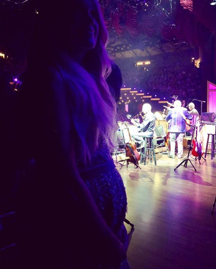 While Carrie Underwood's face may be a little hard to see, her baby bump certainly isn't! The country singer debuted her bump in a photo taken at the Grand Ole Opry on Aug. 10, 2018, where her body largely veiled by the shadows offstage. Underwood and her husband Mike Fisher are also parents to son Isaiah, 3.